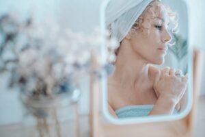 donna adulta riflessa nello specchio durante beauty routine
